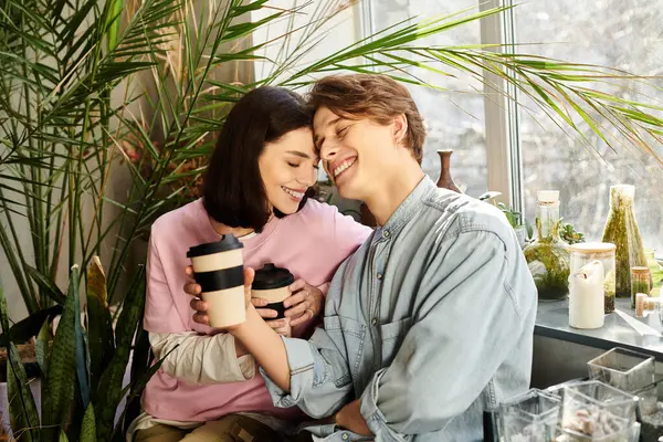 İki arkadaş sanat stüdyosunda sıcak kahve yudumluyor. Bitkiler ve neşe dolu..