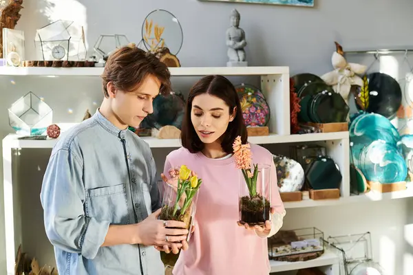 İki genç sanatçı, sanat eserleri arasında çiçek aranjmanları konusunda fikir alışverişinde bulunuyor..