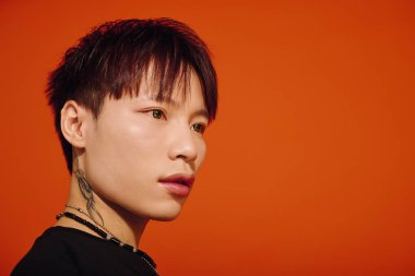 Yakışıklı adam çarpıcı özelliklere sahip modern moda sergiliyor, cesur renklere büyüleyici bir bakış atıyor..