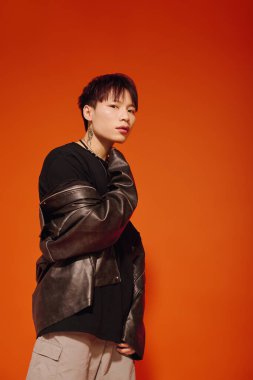 Şık giyinmiş genç, yakışıklı bir adam modern şehir modasını özgüvenle sergiliyor..