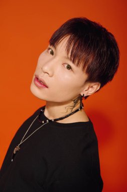 Şık genç adam, çağdaş görünümünü çarpıcı bir arka plana karşı özgüvenle sergiliyor..