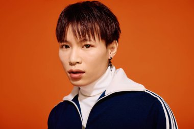 Genç ve yakışıklı Asyalı adam şehir ortamında cesur bir ifadeyle moda sergiliyor..