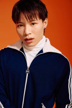 Delikanlı, çarpıcı bir arka plana karşı modaya uygun bir spor giysisine güveniyor.