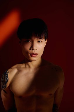 Dövmeli genç adam moda anlayışını ve kendine olan güvenini büyüleyici bir pozda sergiliyor..