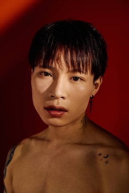 Şık bir Asyalı, kendine olan güvenini çarpıcı kırmızı tonlarda sanatla sergiler..