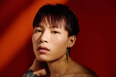 Çekici Asyalı adam benzersiz tarzını sanatsal bir arka planda sergiliyor..