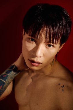 Genç bir Asyalı boynuna neşeyle dokunur, stili ve çekiciliğiyle gösteriş yapar..