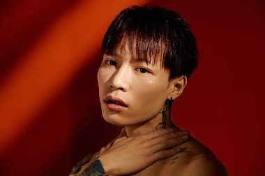 Yakışıklı bir Asyalı genç adam stilini ve karizmasını canlı bir arkaplanda sergiliyor..