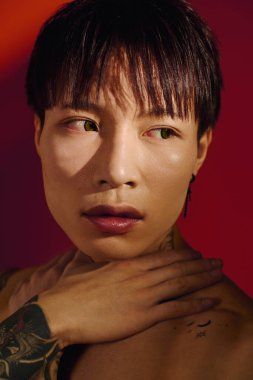 Yakışıklı Asyalı adam dinamik bir ortamda büyüleyici bir ifadeyle şık bir görünüm sergiliyor.