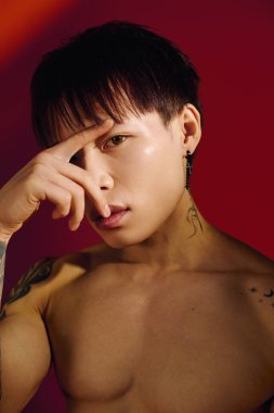 Dövmeleri olan şık, genç bir Asyalı kendine güvenen, çarpıcı özelliklerini sergileyen biri..