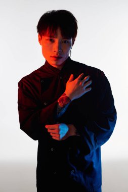 Genç yakışıklı adam moda anlayışını cesur renkleri ve etkileyici duruşuyla sergiliyor..