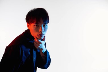 Genç yakışıklı adam minimalist sanatsal düzende zarafet ve stil ile poz veriyor..