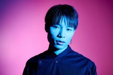 Şık Asyalı adam dikkat çekiyor çarpıcı özellikleri ve çarpıcı renkleriyle bir şehir toplantısında.