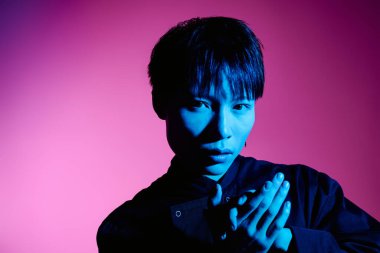 Şık bir genç adam, kendine güvenle tasvir edilir. Kalın ışıklandırma ve moda kıyafetlerle geliştirilmiştir..