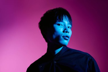 Şık Asyalı adam çarpıcı bir ışıklandırma düzeniyle karizma saçar..