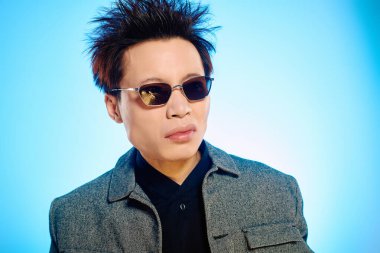 Genç, yakışıklı bir adam açık havada kendine güvenen bir poz verirken moda anlayışını sergiliyor..