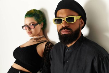 Modaya uygun genç bir çift, kendilerine has tarzlarını sergileyerek stüdyoda güven içinde poz veriyor..