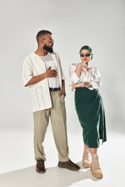 Genç, çok kültürlü bir çift şık kıyafetler ve güneş gözlüğü takıyor..