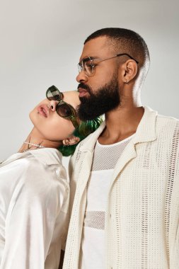 Tarz sahibi bir çift, benzersiz tarzlarını son moda bir stüdyoda sergiliyor, özgüven saçıyor..