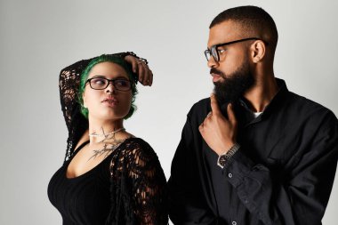 Modern bir stüdyoda kendine güvenen şık bir çift, benzersiz görünüşlerinin altını çiziyor..