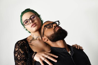 Şık bir çift, canlı bir stüdyoda güneş gözlüğü takarken eşsiz tarzlarını sergiliyor..