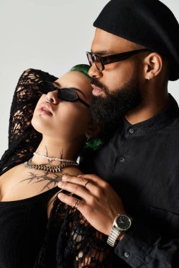 Çok kültürlü genç çift, modaya uygun tarzlarını sergilemek için moda bir stüdyoda birlikte poz veriyorlar..