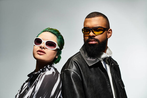 A fashionable couple poses confidently in trendy sunglasses, highlighting their unique style.