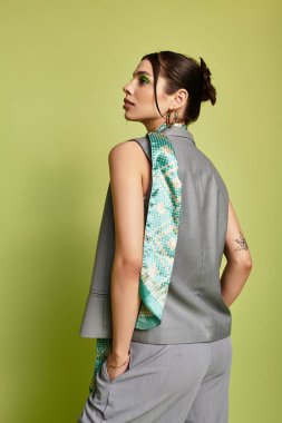 Şık bir kadın eşsiz bir üst ve canlı bir arka plana karşı aksesuarlarla zarafeti ön plana çıkarıyor.