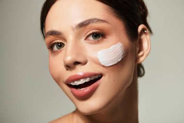 Neşeli bayan cilt bakımını sever. Doğal güzelliğini taze bir kremle arttırır..