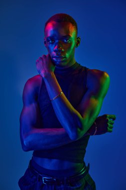 Şık bir genç adam kendine güveni canlı bir arka plana çarpıcı bir pozla yayar..