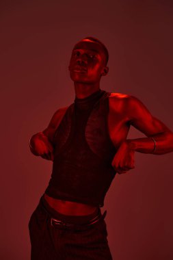 Genç bir Afrikalı Amerikalı, şık kıyafetlerini cesur ve enerjik bir şekilde sergiliyor..