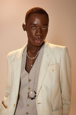 Kendinden emin genç Afro-Amerikan erkeği canlı moda ve şık aksesuarlar sergiliyor..