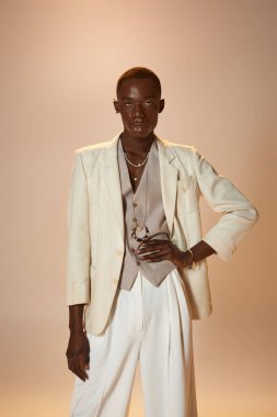 Afrikalı genç bir Amerikalı şık bir terzi ceketi ve şık aksesuarlarıyla karizma sergiliyor..