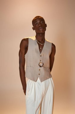 Afrikalı Amerikalı genç bir adam, tarafsız bir arkaplan karşısında kendine güvenen modaya uygun modeller..