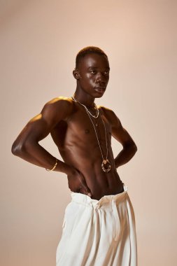 Şık genç adam yaratıcı bir stüdyo ortamında enerjik ve kendine güvenen pozunu sergiliyor..