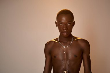 Genç bir Afro-Amerikan erkeği şık tarzını sanatsal ve canlı bir atmosferde sergiliyor..