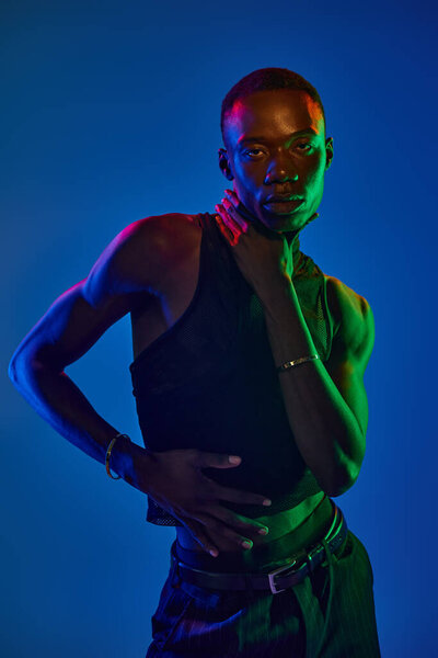 Молодой африканский американец демонстрирует стильный наряд, излучая уверенность среди богатых цветов.