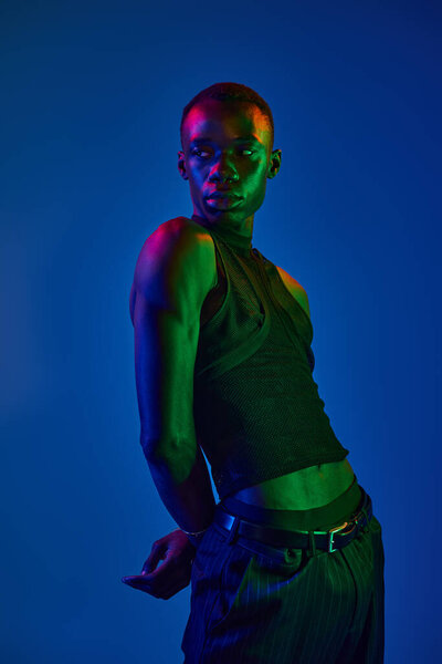 Молодой африканский американец демонстрирует стильную одежду и уверенность в ярком освещении.