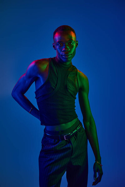 Молодой африканский американец демонстрирует свой стиль против ярких красок, воплощая современную моду.