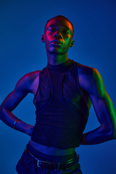 A young african american man poses confidently in vibrant attire that showcases his style.