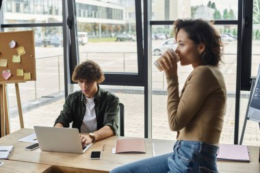Kendini işine adamış iki iş arkadaşı modern ofis ortamında üretken faaliyetlerde bulunuyor..