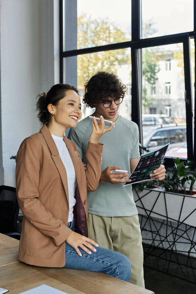 Colleagues engage in a lively discussion while reviewing a project in a well lit workspace.