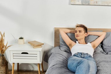 Güzel genç bir kadın rahatça yatağında dinleniyor, kendine güven ve pozitiflik yayıyor..