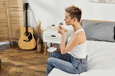 Güzel bir kadın dingin bir alanda dinlenir, çay içerken kendine güven ve neşe saçar..