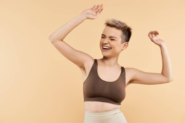 Neşeli genç bir kadın, sıcak bir arkaplana pozitifliğini yayarak güvenini ifade eder..