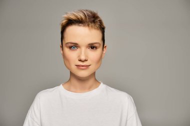 Benzersiz özelliklere sahip genç bir kadın tarafsız bir arkaplana karşı güven ve pozitiflik yayar..