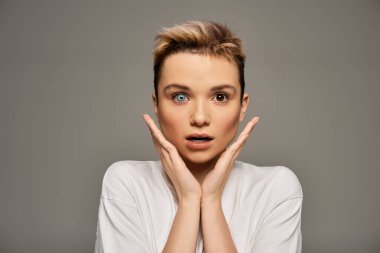 Kendine güvenen kadın, güzel özelliklerini ve vücudunun pozitifliğini minimalist bir zeminde sergiliyor..