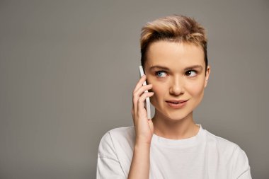 Güzel genç bir kadın bir telefon görüşmesi sırasında kendine güvenini ve pozitifliğini ifade eder, neşe saçar..