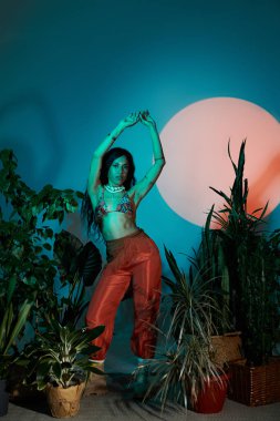 Canlı genç bir kadın yemyeşil bir ortamda zarif bir şekilde dans ediyor, neşe saçıyor ve yaz enerjisi saçıyor..