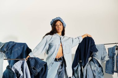 Genç kadın mavi kot elbiseleriyle zarif poz veriyor, yaz modası havası ve kendine güveni yayıyor..